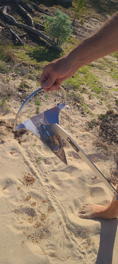 Mantus dinghty anchor about to be installed in the sand